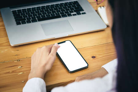 Woman hand holding smartphone Blank screen mobile phone for graphic display montage.