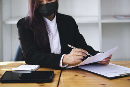A businesswoman is researching earnings affected by the coronavirus pandemic to adjust her market...
