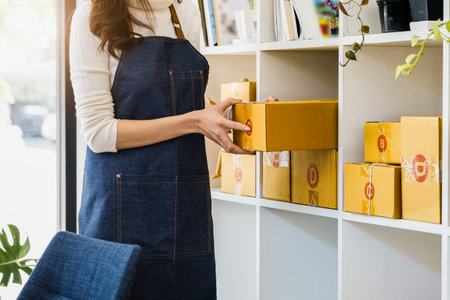 Work from home. happy women selling products online Startup small business owners are picking up parcel boxes to pack customer orders and prepare them for postage.の写真素材