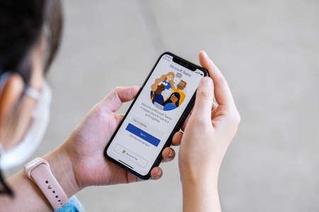 Chiangmai, Thailand - NOV 28, 2021: A user opens the Microsoft Teams mobile app. Teams is a unified team communication and collaboration platform with workplace chat, video meetings, and file storage.のeditorial素材