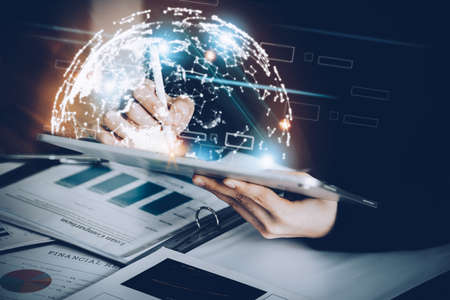 Business woman using a tablet to work through the internet technology for the digital marketing era,...