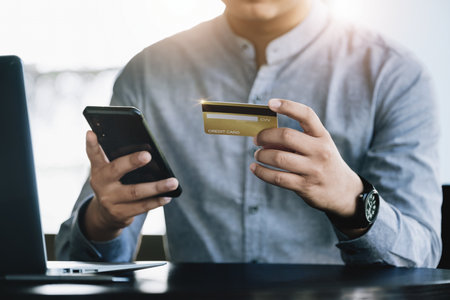Online Shopping and Internet Payments, Asian man are using their credit card and mobile phone to...