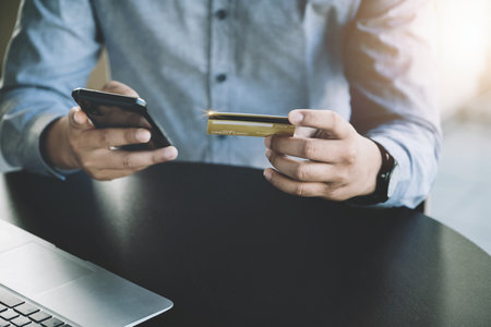 Online Shopping and Internet Payments, Asian man are using their credit card and mobile phone to...