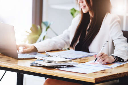 Investment concepts, businesswomen use document and computers to analyze stock markets, quantitative data collection, financial statement analysis, profitability through internet technology.の写真素材