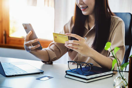 Online Shopping and Internet Payments, Beautiful Asian women are using their credit cards and mobile...