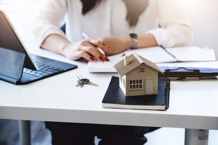Entrepreneurs, business owners, accountants, real estate agents, focusing on tabletop home models with women using home equity budget calculators to assess their financial risks.の写真素材
