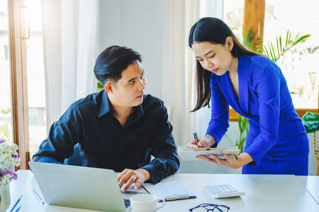 negotiation, analysis, discussion,asian female economist pointing out a document explaining the...