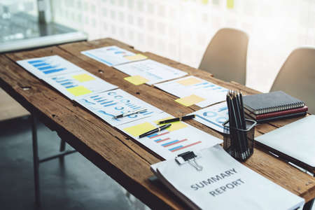 Brainstorming, consultation, data analysis, planning, marketing, accounting, economics, meeting budget papers placed on a wooden table.の写真素材