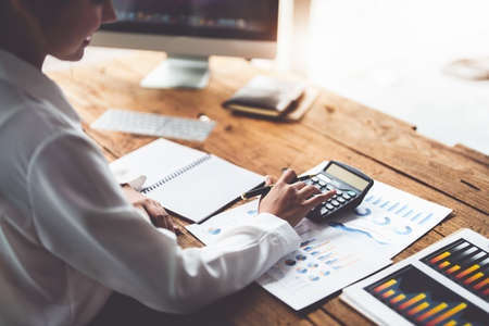 accountant, Auditor, Self-Employed, Finance and Investment, tax calculation and budget, Asian female entrepreneur using a calculator to calculate. Company business results document.の写真素材