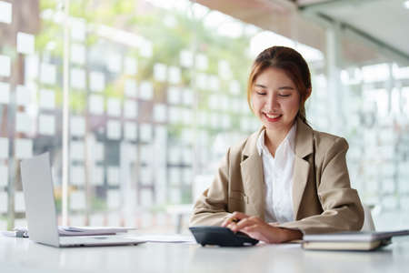 accountant, Auditor, Self-Employed, Finance and Investment, tax calculation and budget, Portrait of Asian female entrepreneur using a calculator to calculate. Company business results document.の写真素材