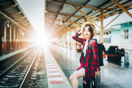 summer, relax, vacation, travel, portrait of cute Asian girl showing smile and waiting at the train...