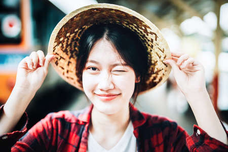 summer, relax, vacation, travel, portrait of cute Asian girl showing smile and showing joy while waiting at the train station for a summer tripの写真素材