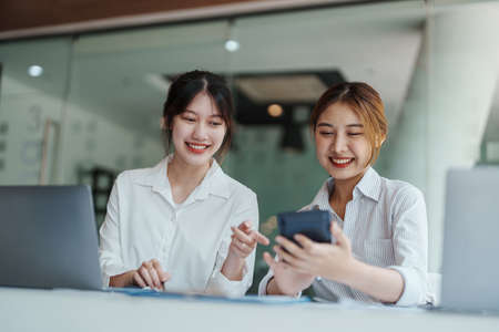 financial, Planning, Marketing and Accounting, portrait of Asian woman Economist using calculator to calculate investment documents with partners on profit taking to compete with other companies.の写真素材