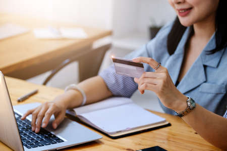 Online Shopping and Internet Payments, Beautiful Asian women are using their credit cards and computer laptop to shop online or conduct errands in the digital world.の写真素材