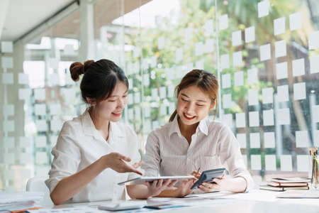 Negotiation, Analysis, Discussion, Portrait of an Asian women economist and marketer using tablet...