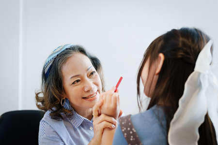 Asian portrait, grandchild granddaughter grandma grandmother and granddaughter happily join in activities to enhance skills for grandchildren.の写真素材