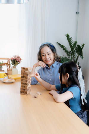 Asian portrait, grandchild granddaughter grandma grandmother and granddaughter happily join in activities to Block wood game Puzzle and enhance skills for grandchildren.の写真素材