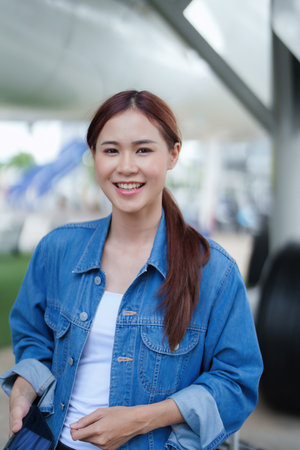travel business Portrait of an Asian woman showing joy while waiting for a flight.