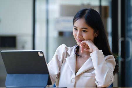 Budget, finance, woman marketer is using tablet computer for document analysis to manage investment planning risks for the company they work for.の写真素材