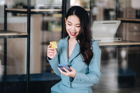 Online Shopping and Internet Payments, Beautiful Asian women are using their credit cards and mobile...