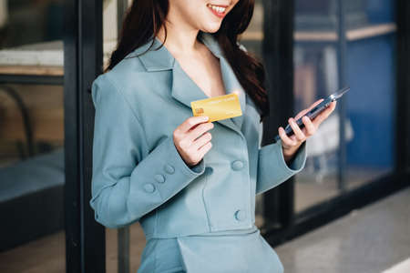 Online Shopping and Internet Payments, Beautiful Asian women are using their credit cards and mobile phones to shop online or conduct errands in the digital worldの写真素材