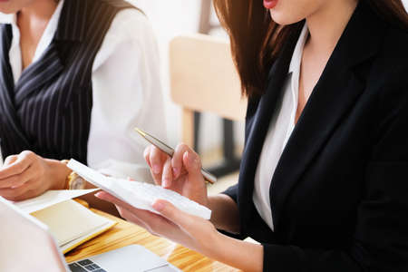 woman working with finance calculate on calculator and using computer laptop and document data chart...