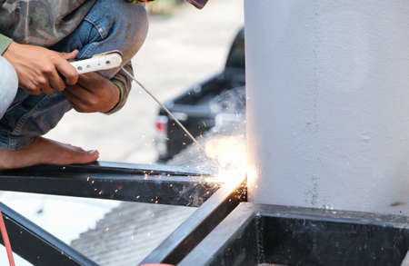The welder is welding the steel structure to add to the house