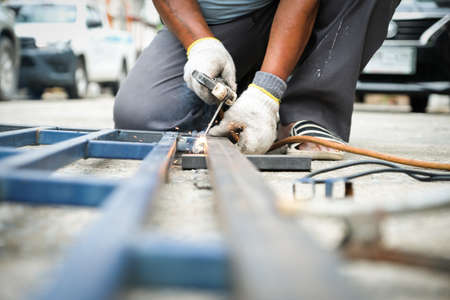 The welder is welding the steel structure to add to the house