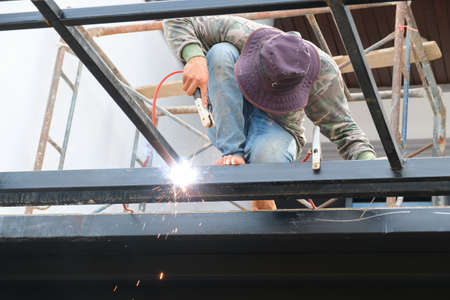 The welder is welding the steel structure to add to the houseの写真素材