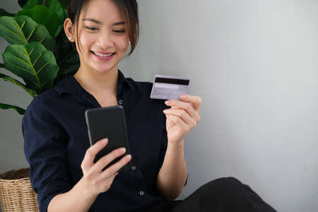 Online payment, Young Womens hands holding credit card and using smartphone for online shopping at...