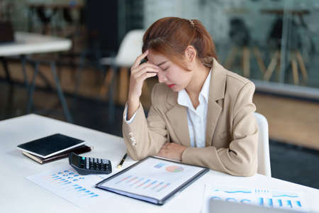 Burnout Syndrome. Portrait of Asian Business Woman feels uncomfortable working. Which is caused by stress, accumulated from unsuccessful work And less resting body. Consult a specialist psychiatristの写真素材