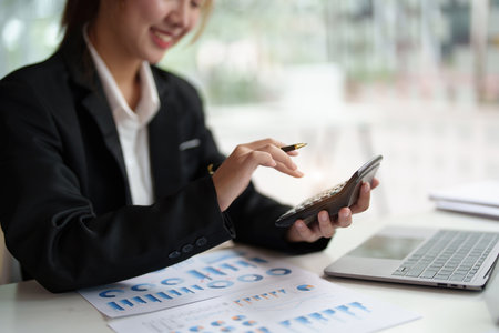 accountant, Auditor, Self-Employed, Finance and Investment, tax calculation and budget, Asian female entrepreneur using a calculator to calculate. Company business results documentの写真素材