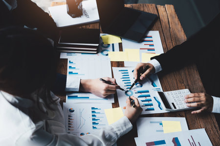 financial, Brainstorming, Consulting, Data Analysis, Planning, Marketing and Accounting, Economists pen pointing to investment documents with partners on profit taking to compete with other companiesの写真素材