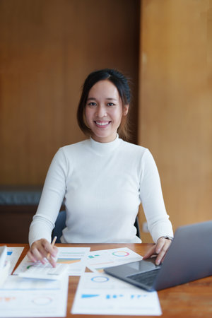 Accountants, Asian auditors are using calculators and computers to review annual tax budgets to submit information to the IRSの写真素材