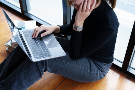 Portrait of an Asian woman using a computer to study online and drinking coffee while video conference.の写真素材