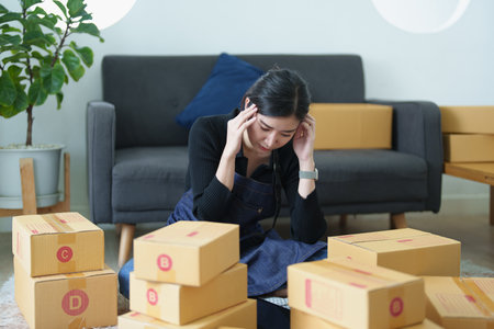Startup small business entrepreneur of independent young Asian woman using uncheerful unsuccessful...