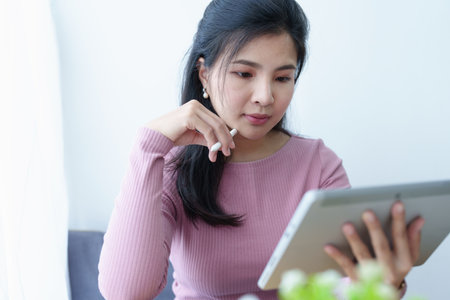 Portrait of a beautiful Asian teenage girl using a tablet computer.の写真素材