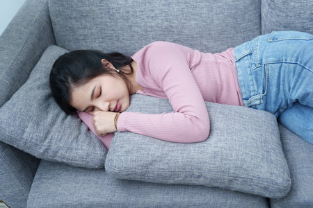 Portrait of a beautiful Asian teen girl relaxing on the sofa at home.の写真素材