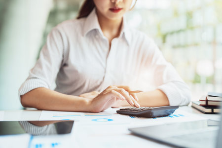 accountant, Auditor, Self-Employed, Finance and Investment, tax calculation and budget, Asian female entrepreneur using a calculator to calculate. Company business results documentの写真素材