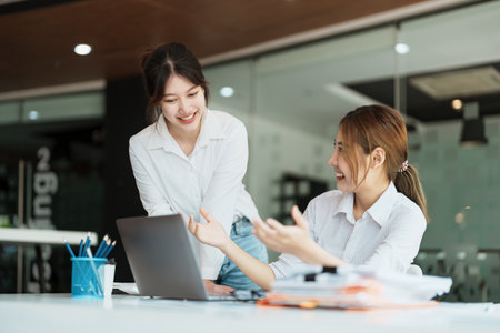 Negotiation, Analysis, Discussion: Portrait of an Asian female economist and marketer using computer laptop to plan investments and financial to prevent risks and losses for the company.の写真素材