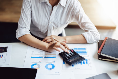 accountant, Auditor, Self-Employed, Finance and Investment, tax calculation and budget, Asian female entrepreneur using a calculator to calculate. Company business results documentの写真素材