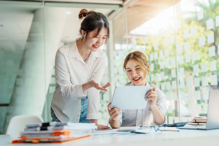 Negotiation, Analysis, Discussion, Portrait of an Asian women economist and marketer using tablet computer to plan investments and financial to prevent risks and losses for the company.の写真素材