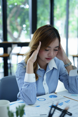 Portrait of sme business owner, woman using computer and financial statements Anxious expression on expanding the market to increase the ability to invest in business.の写真素材