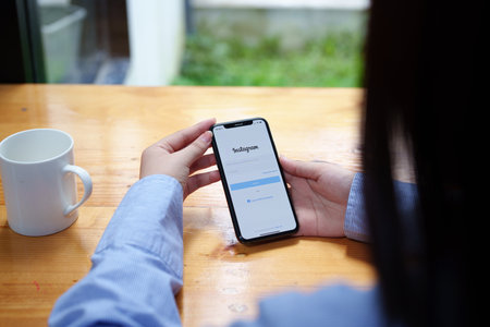 CHIANG MAI, THAILAND - Jun 30, 2022 : woman hand holding smartphone mobile with login screen of instagram application. Instagram is largest and most popular photograph social networking.のeditorial素材