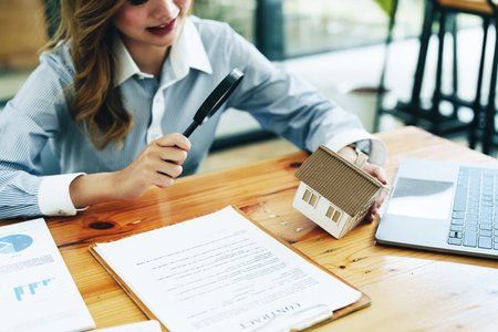 customer holding a magnifying glass to look at a house model, concept of home inspection before buying a house and landの写真素材