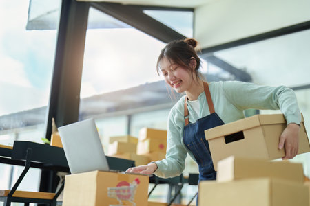 A portrait of a small startup, an SME owner, an Asian female entrepreneur checking orders to arrange...