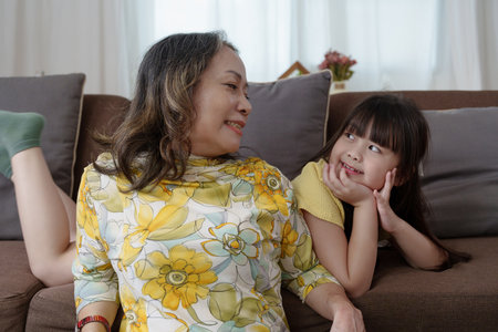 Asian portrait, grandma and granddaughter doing leisure activities and hugging to show their love and care for each other.の写真素材