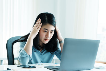 Portrait of sme business owner, woman using computer and financial statements Anxious expression on...