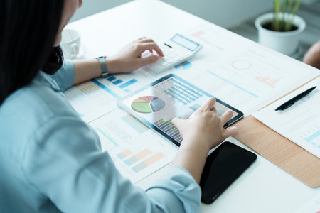 financial, Planning, Marketing and Accounting, portrait of Asian employee checking financial statements using tablet, documents and calculators at work..の写真素材