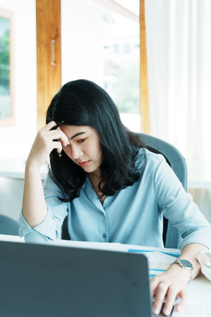 Portrait of sme business owner, woman using computer and financial statements Anxious expression on...